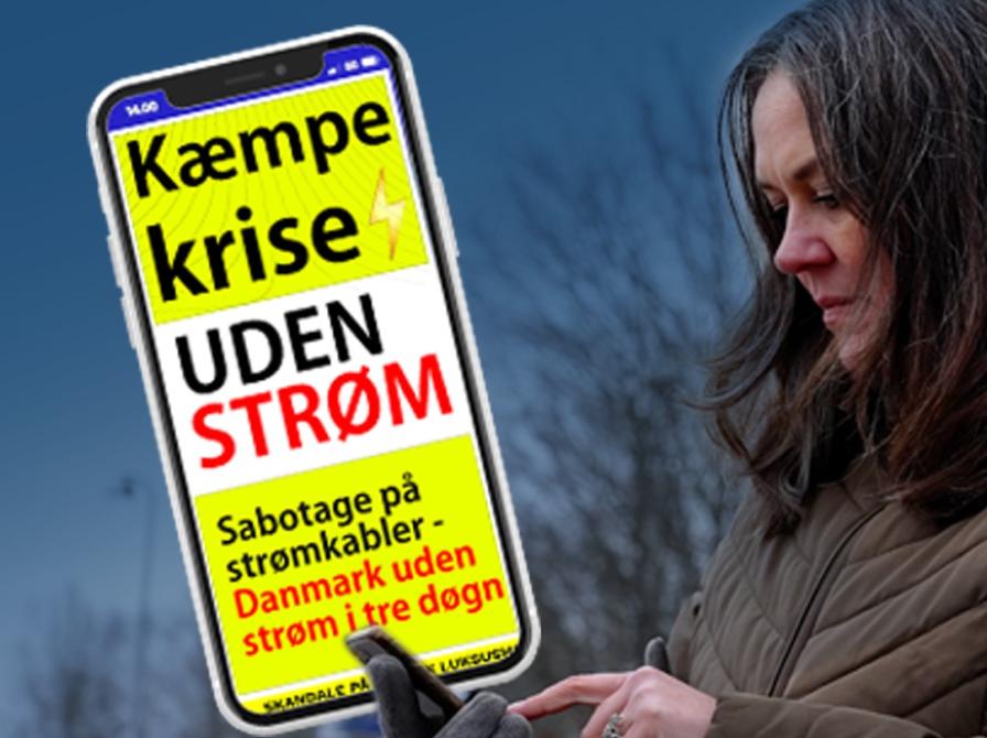 Dame med mobil der viser nyhed: Kæmpe krise - uden strøm